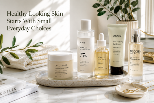 Elegant Korean skincare products arranged on a natural stone tray with fresh greenery and warm morning light, representing healthy daily skincare habits.
